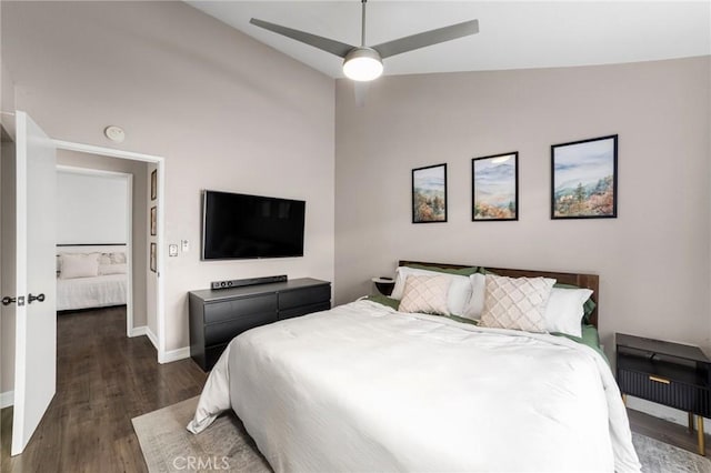 bedroom with dark hardwood / wood-style flooring, vaulted ceiling, and ceiling fan