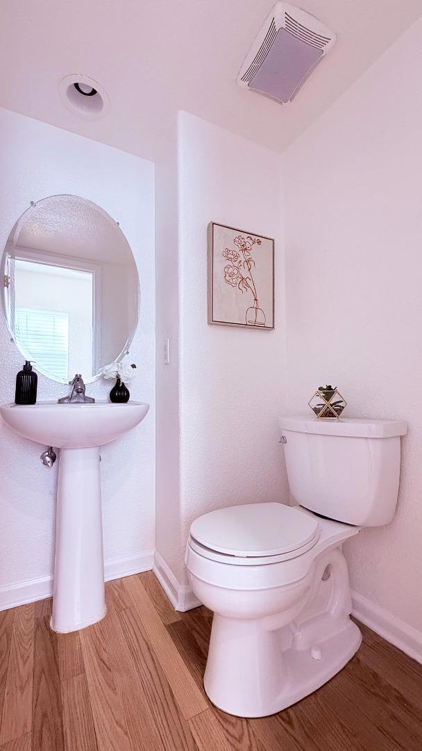 bathroom with hardwood / wood-style floors and toilet