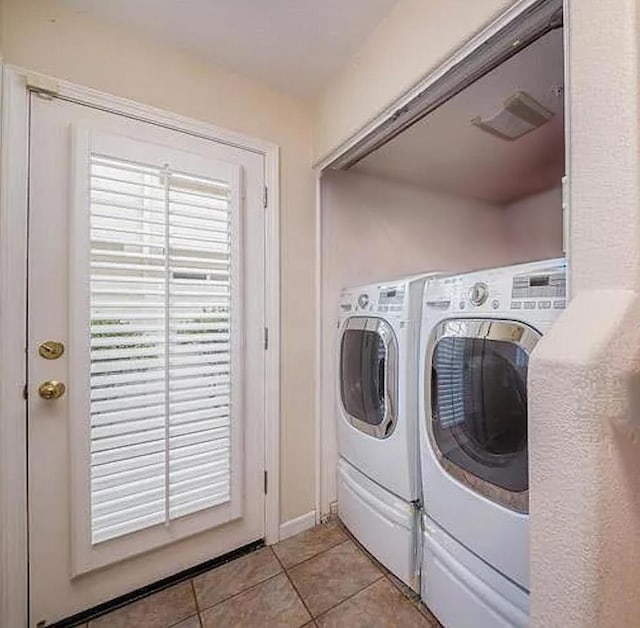 laundry room with washing machine and dryer and light tile patterned floors