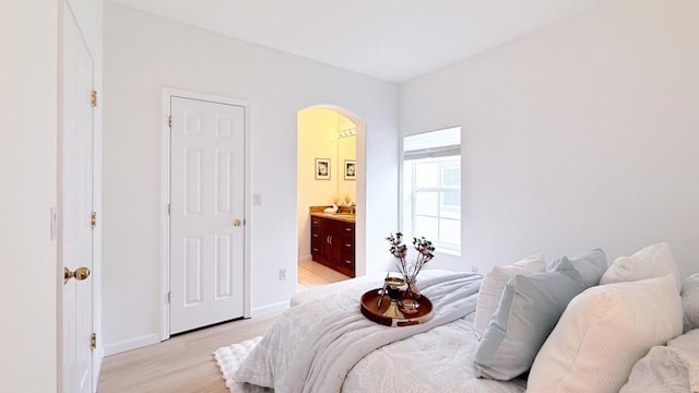 bedroom featuring light hardwood / wood-style floors and ensuite bathroom