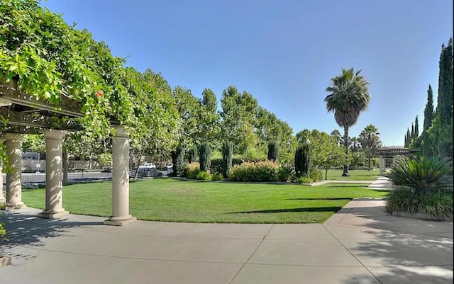 view of property's community with a pergola and a lawn