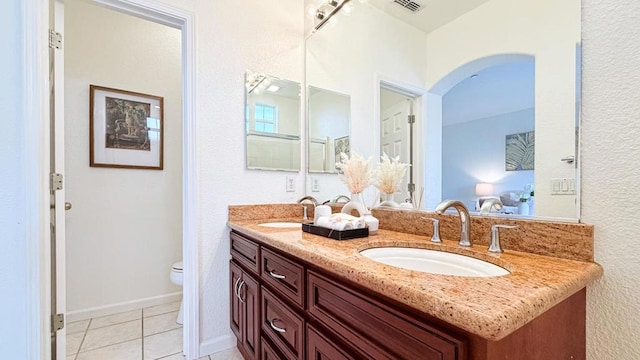 bathroom with vanity, tile patterned floors, and toilet