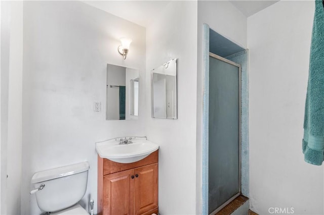 bathroom featuring vanity, toilet, and an enclosed shower