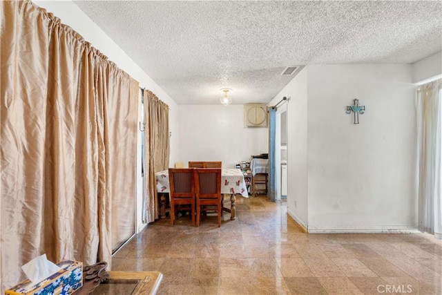 dining room featuring a barn door and a textured ceiling