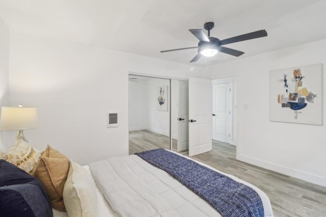 bedroom with ceiling fan, light hardwood / wood-style floors, and a closet