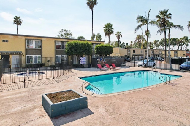 view of pool with a hot tub and a patio area