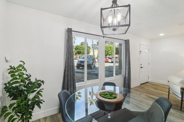 dining area with wood-type flooring and a notable chandelier