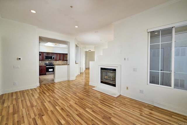 unfurnished living room with crown molding and light hardwood / wood-style floors