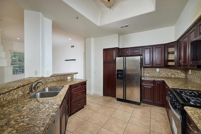 kitchen with sink, gas range, tasteful backsplash, light stone counters, and stainless steel fridge with ice dispenser