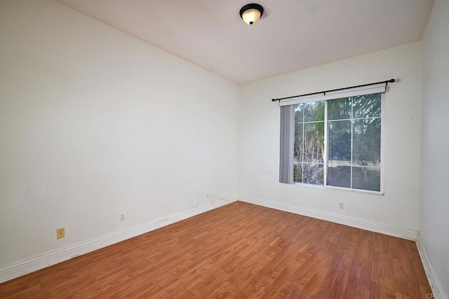 unfurnished room with hardwood / wood-style flooring