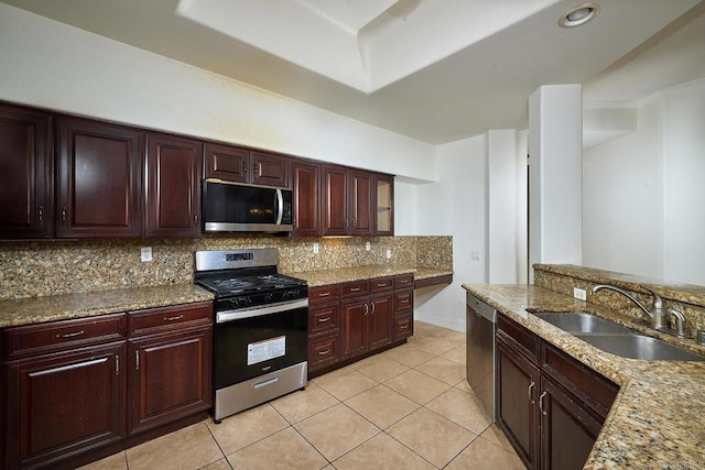 kitchen featuring sink, appliances with stainless steel finishes, tasteful backsplash, light stone countertops, and light tile patterned flooring