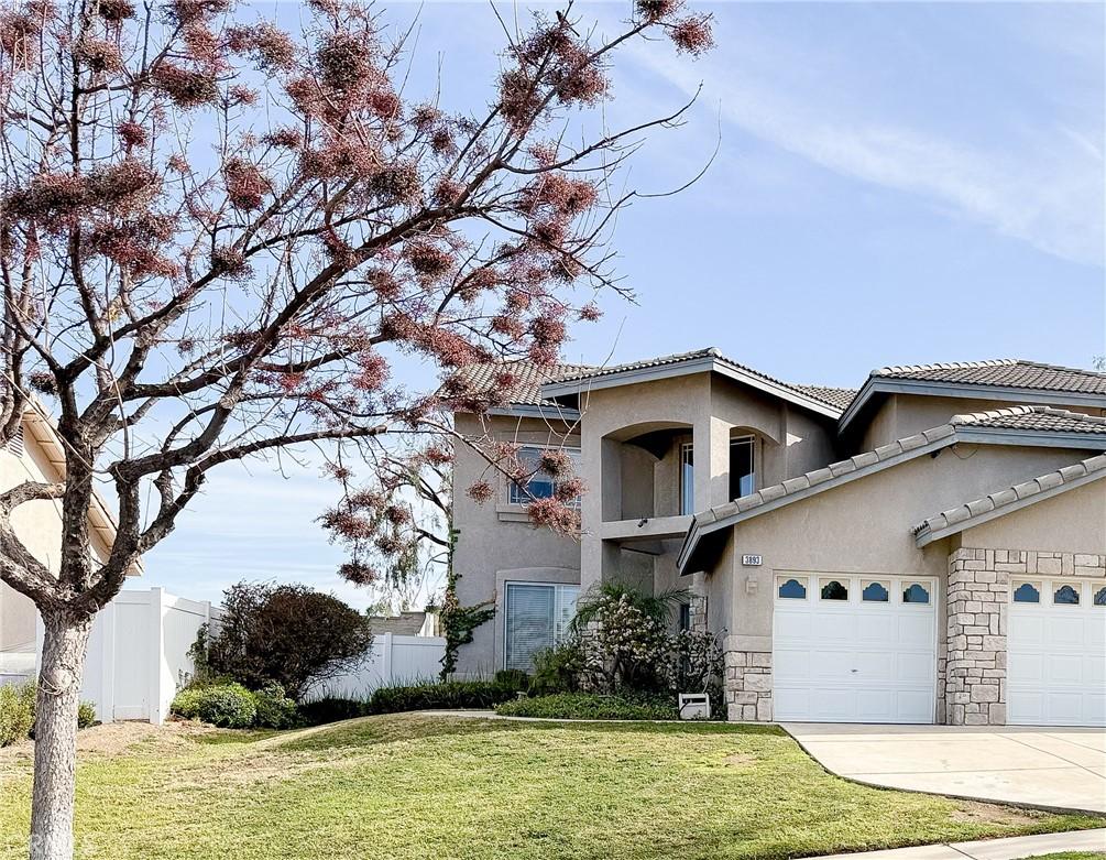 view of front of home featuring driveway, fence, a front lawn, and stucco siding