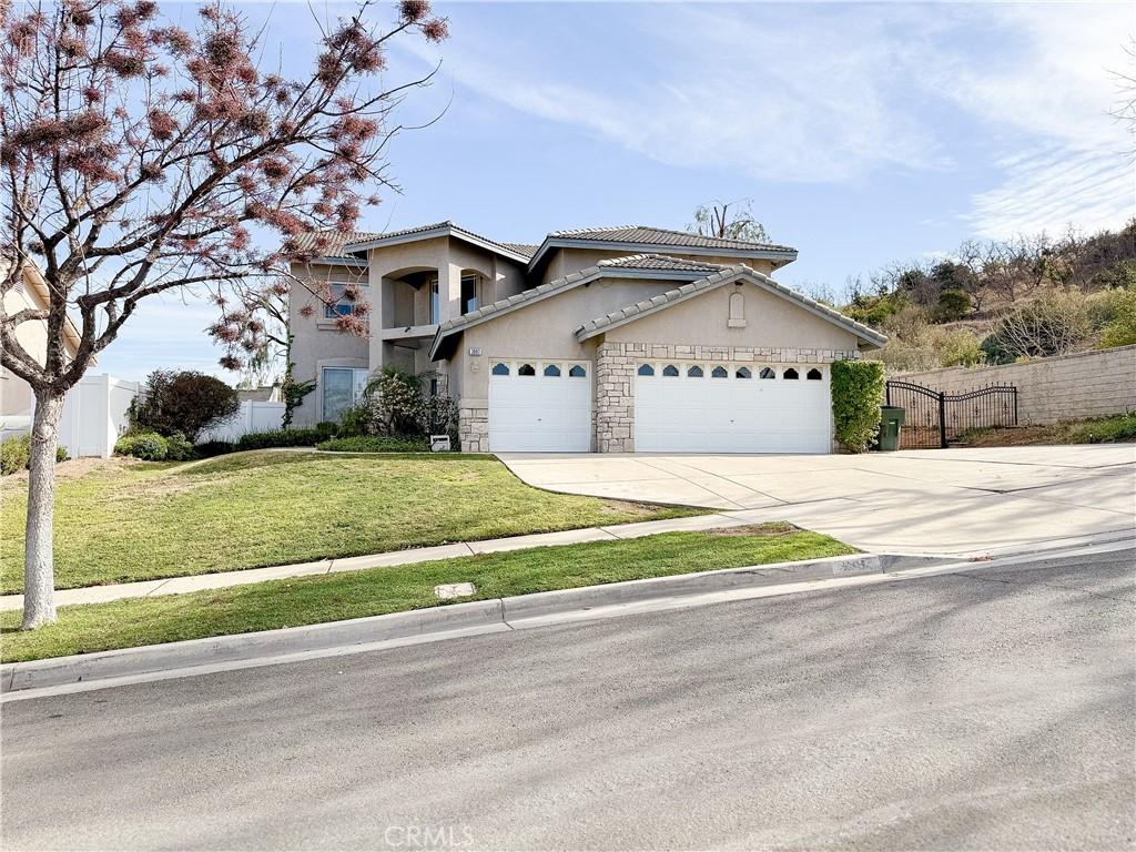 view of front of property with a garage, fence, concrete driveway, stucco siding, and a front lawn