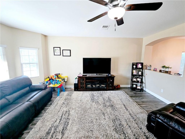 living room with ceiling fan and dark hardwood / wood-style flooring