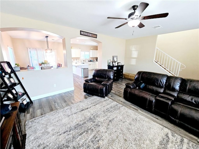 living room featuring light hardwood / wood-style flooring and ceiling fan