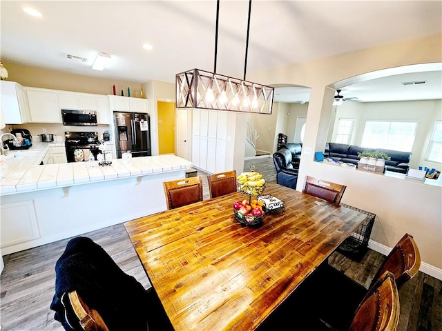 dining space featuring ceiling fan, dark hardwood / wood-style floors, and sink