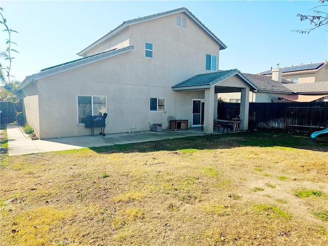 back of property with a patio area and a lawn