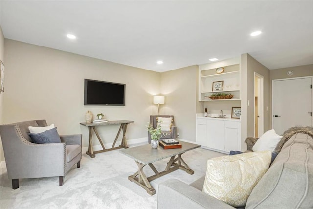 carpeted living room with sink and built in features