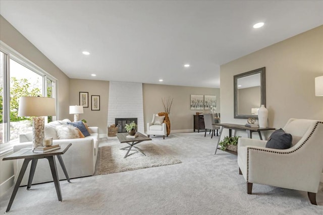 carpeted living room with a brick fireplace