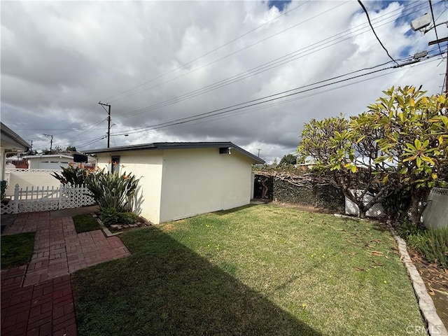 view of yard featuring an outbuilding, a fenced backyard, and a patio area