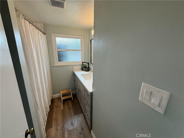 bathroom with vanity, visible vents, curtained shower, wood finished floors, and baseboards