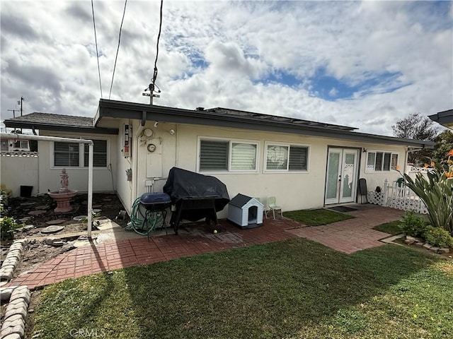 back of property featuring a patio and a yard