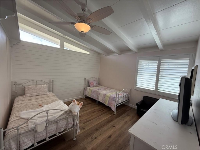 bedroom with wood finished floors, wooden walls, lofted ceiling with beams, and baseboards