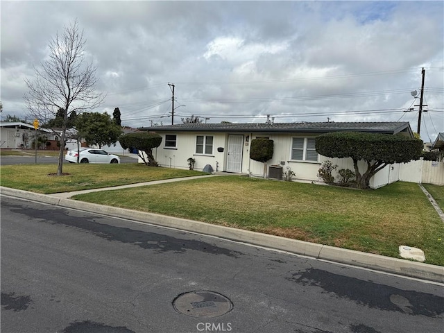 ranch-style home with a front lawn and central air condition unit