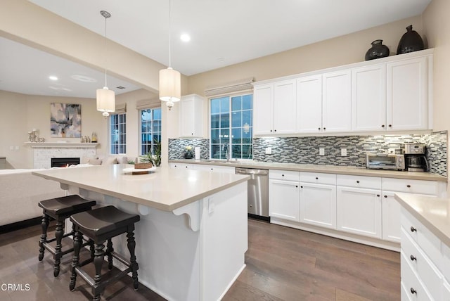 kitchen featuring white cabinetry, hanging light fixtures, and stainless steel dishwasher