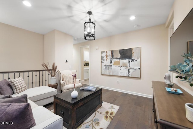 living room with an inviting chandelier and dark hardwood / wood-style flooring