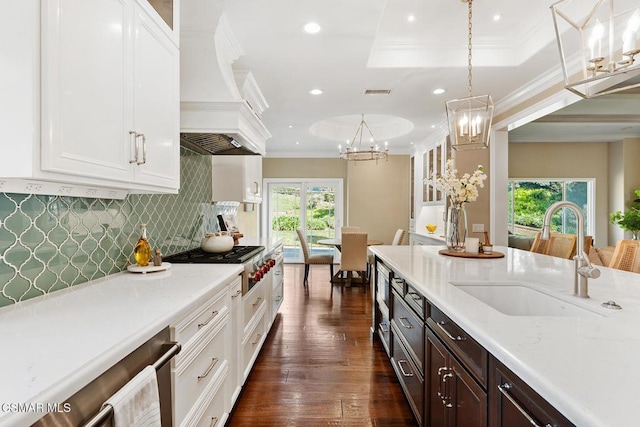 kitchen with sink, white cabinetry, decorative light fixtures, dark hardwood / wood-style flooring, and stainless steel gas stovetop