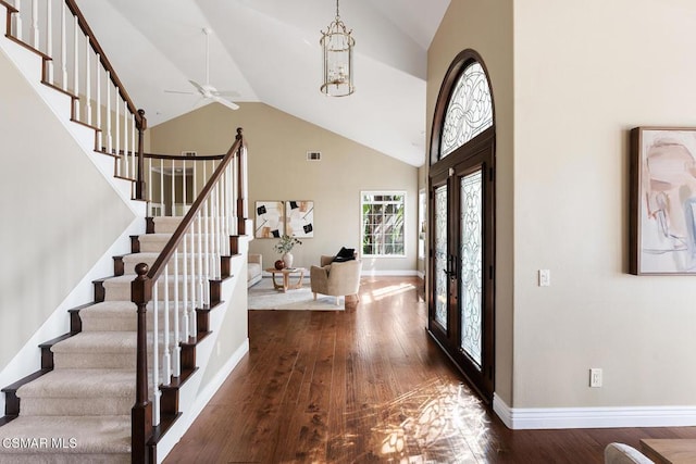 entrance foyer featuring high vaulted ceiling, a notable chandelier, and dark hardwood / wood-style flooring