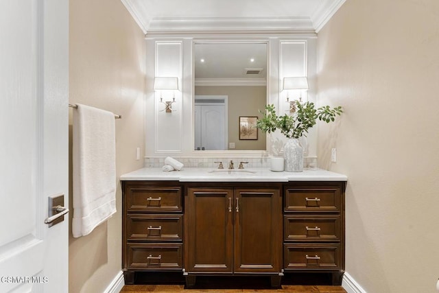 bathroom with vanity, crown molding, and tasteful backsplash