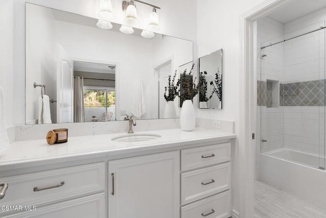 bathroom featuring tiled shower / bath and vanity