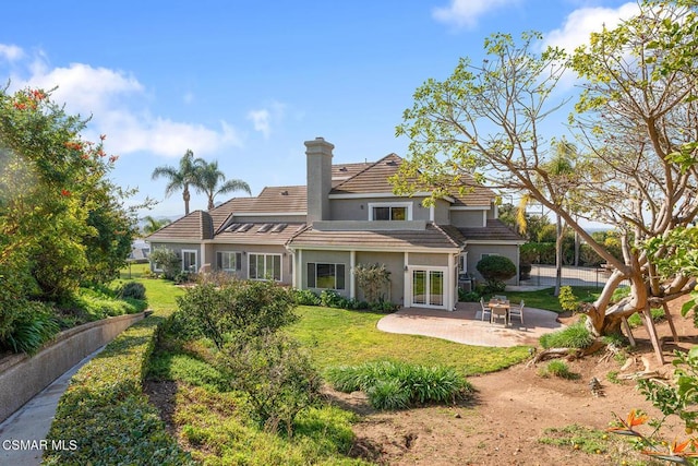 back of property with a patio and a yard