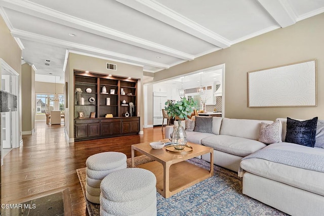 living room with crown molding, wood-type flooring, and beam ceiling