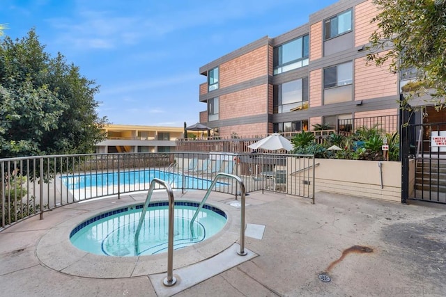 view of swimming pool with a community hot tub