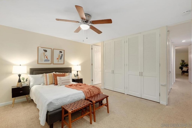 bedroom featuring light colored carpet, ceiling fan, and a closet