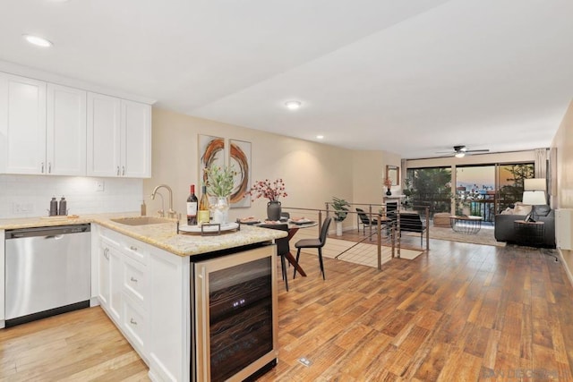 kitchen with white cabinetry, stainless steel dishwasher, beverage cooler, and sink