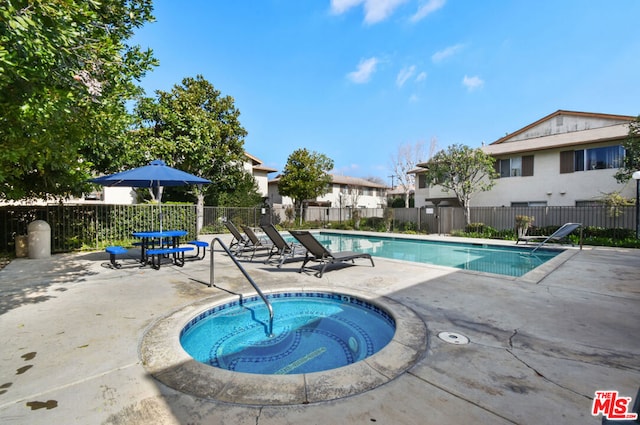 view of swimming pool featuring a patio area and a hot tub