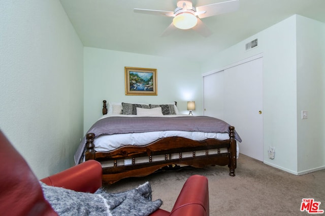 bedroom with ceiling fan, a closet, and light carpet