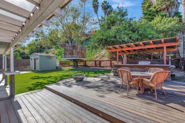 wooden terrace with a storage shed, a pergola, and a yard