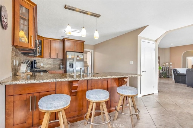 kitchen featuring sink, stainless steel appliances, a kitchen breakfast bar, and kitchen peninsula