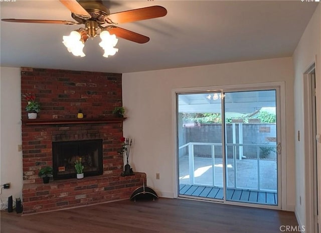 living room featuring ceiling fan, dark hardwood / wood-style floors, and a brick fireplace