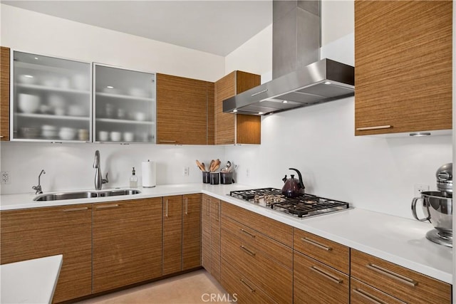 kitchen with sink, stainless steel gas cooktop, and wall chimney exhaust hood