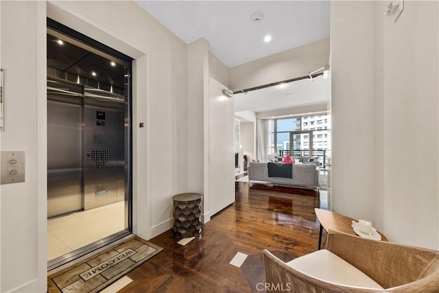 corridor featuring elevator and dark hardwood / wood-style flooring