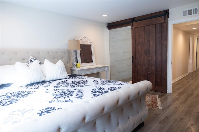 bedroom featuring dark hardwood / wood-style floors and a barn door