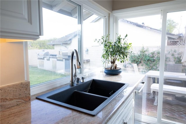 kitchen featuring white cabinetry and sink