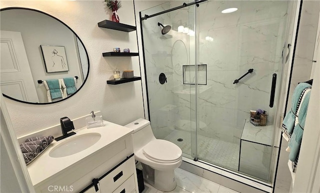 bathroom with vanity, a shower with door, and toilet