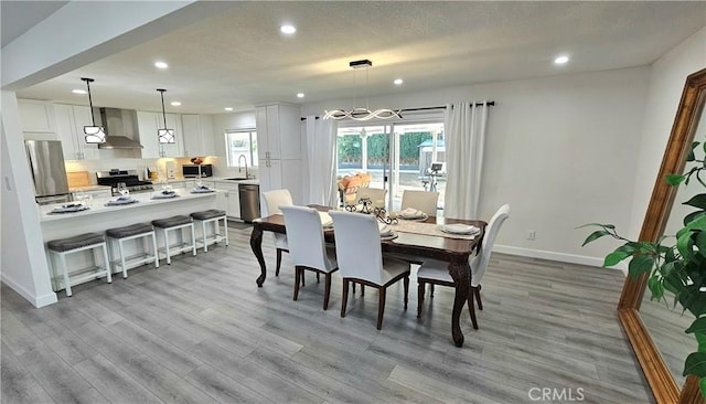 dining area with sink and light wood-type flooring